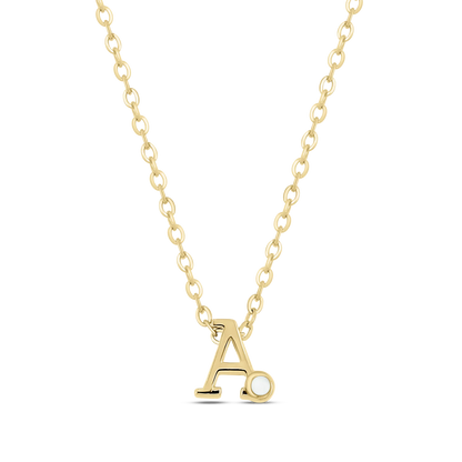 Le collier Anna | Initiale Lait Maternel Or de Mama Jewels présente un pendentif « A » en or orné dune petite perle sur une chaîne délicate, créant des bijoux uniques sur fond noir.