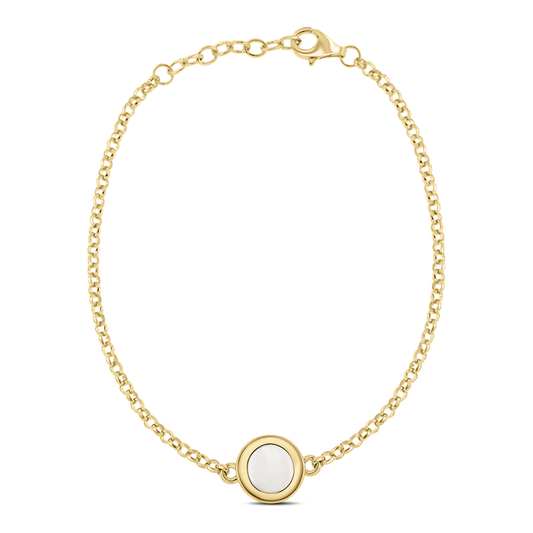 Bracelet en or jaune avec une chaîne délicate et un pendentif rond en résine contenant du lait maternel.
