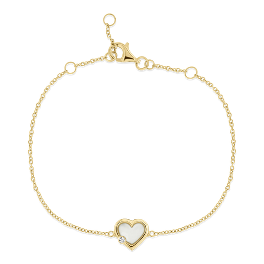 Bracelet en or jaune avec un pendentif en forme de cœur en résine contenant du lait maternel et un zircon.