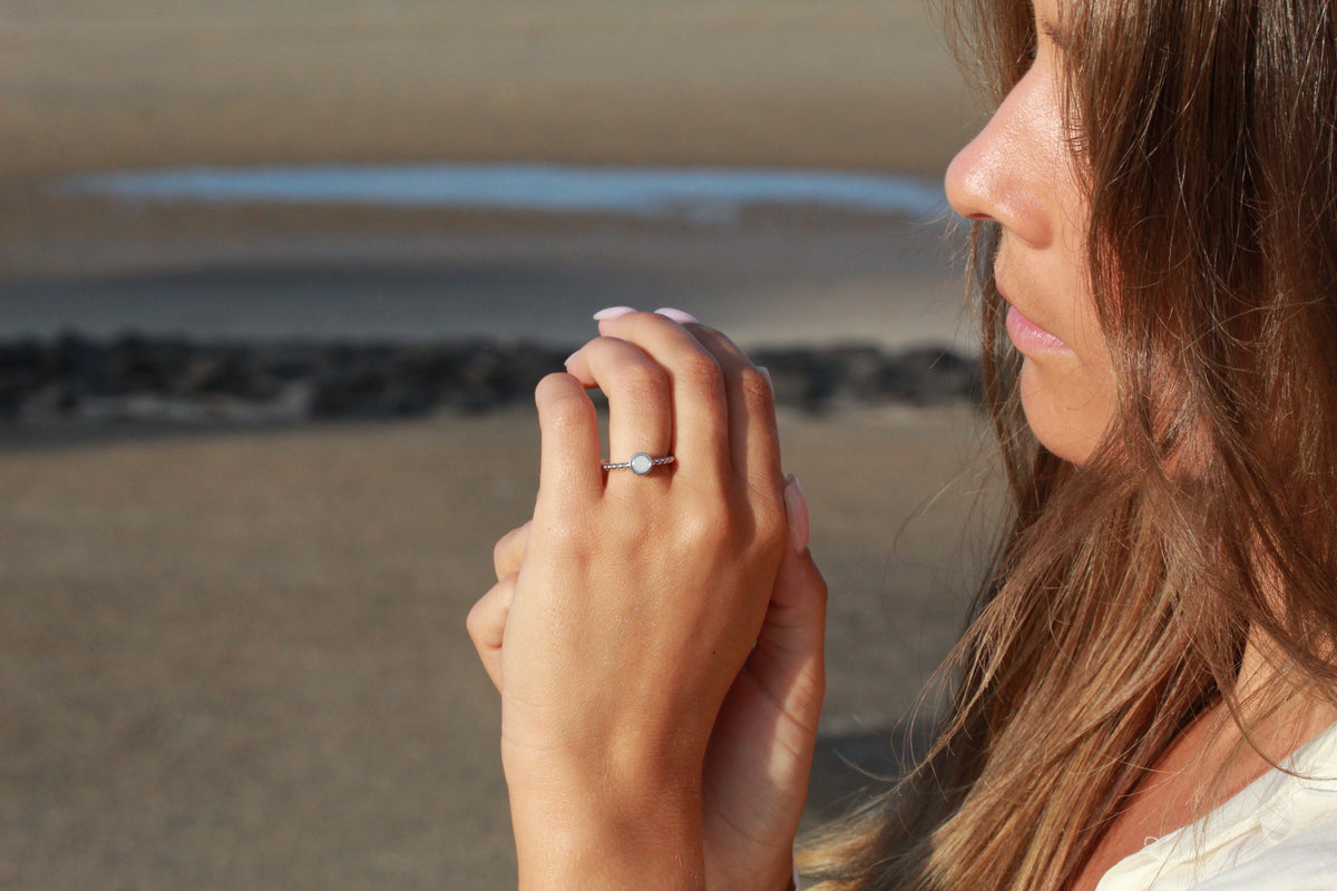 Femme de profil à la plage, mains jointes, bague Isabelle en argent au doigt