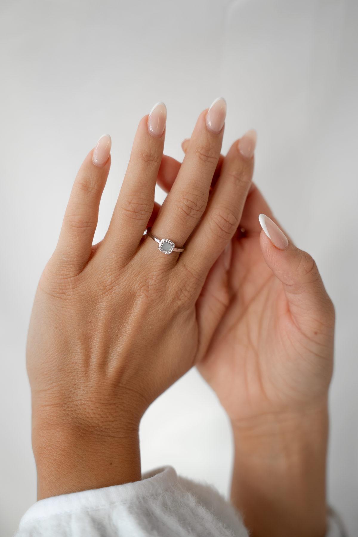 Deux mains levées, bague Lara couleur argent avec couronne de petites pierres à l'annulaire