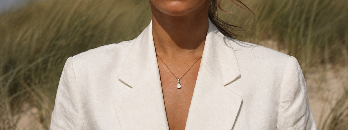 Femme portant un pendentif goutte au lait maternel en or