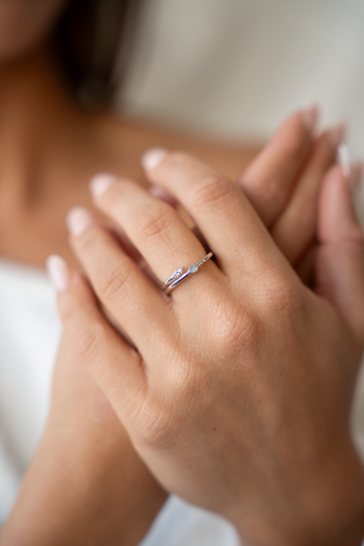 Mains croisées, bague Naomi couleur argent à deux extrémités, goutte de lait maternel et pierre navette